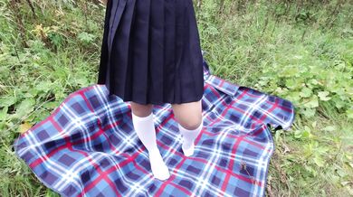 Schoolgirl in uniform shows legs feet foot in white knee socks and pantyhose under skirt